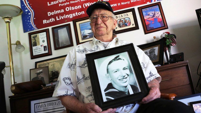 In this Nov. 17, 2016, file photo, Lauren Bruner, a survivor of the USS Arizona which was attacked on Dec. 7, 1941, holds with a 1940 photo of himself at his home in La Mirada, Calif. Divers will place the ashes of Bruner in the wreckage of his ship during a ceremony this weekend in Pearl Harbor, Hawaii. Bruner died earlier in 2019 at the age of 98.