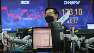 In this April 3, 2020, file photo, a currency trader wearing a face mask works at the foreign exchange dealing room of the KEB Hana Bank headquarters in Seoul, South Korea.