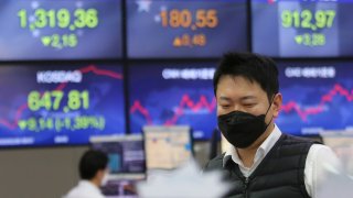 In this Feb. 26, 2020, file photo, a currency trader watches monitors at the foreign exchange dealing room of the KEB Hana Bank headquarters in Seoul, South Korea.