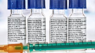 Etiqueta de instrucciones en botellas médicas de Remdesivir y una jeringa de inyección cerca. GS-5734 es un medicamento antiviral desarrollado por Gilead Sciences, posible tratamiento del coronavirus.