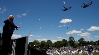 President Donald Trump applauds as Army helicopters fly over and West Point cadets toss their caps into the air at the end of commencement ceremonies on the parade field, at the United States Military Academy in West Point, N.Y., Saturday, June 13, 2020.