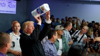 President Donald Trump tosses paper towels into a crowd at Calvary Chapel in Guaynabo, Puerto Rico, on Oct. 3, 2017.