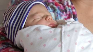 A mother holds a newborn baby.