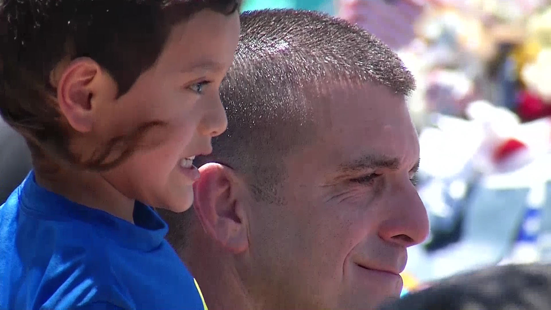 A man and his son pose for a photo at the Dallas Police Headquarters memorial.