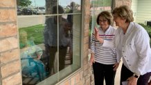 96 year old Betty Williams visits with family members through a window at the Santa Fe Trails nursing home in Cleburne.