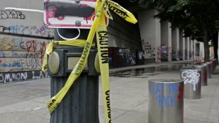 Graffiti from recent demonstrations covers an area outside of the Mark O. Hatfield Federal Courthouse in downtown Portland, Ore., on Wednesday, July 8, 2020. Protesters who have clashed with authorities in Portland, Ore., are facing off not just against city police but a contingent of federal agents who reflect a new priority for the Department of Homeland Security: preventing what President Donald Trump calls "violent mayhem." The agents clad in military-style uniforms include members of an elite Border Patrol tactical unit, and their deployment to protect federal buildings and monuments is a departure for an agency created to focus on threats from abroad.