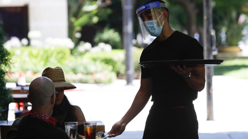 In this July 18, 2020, file photo, a waiter takes a food order in Burbank, Calif.