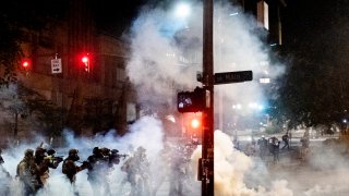 Federal agents use crowd control munitions to disperse Black Lives Matter protesters near the Mark O. Hatfield United States Courthouse on Monday, July 20, 2020, in Portland, Ore. Officers used teargas and projectiles to move the crowd after some protesters tore down a fence fronting the courthouse.