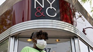 A pedestrian wearing a protective mask walks past a temporarily closed New York & Co. store in Silver Spring, Maryland, U.S., on Friday, June 5, 2020.