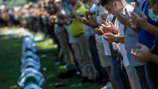 SREBRENICA, BOSNIA AND HERCEGOVINA – Bosnian Muslims pray during a mass funeral on July 11, 2020, at the cemetery for the victims of Srebrenica genocide. More than 8,000 Bosnian Muslim men and boys were killed after the Bosnian Serb Army attacked Srebrenica, a designated UN safe area in July 1995.