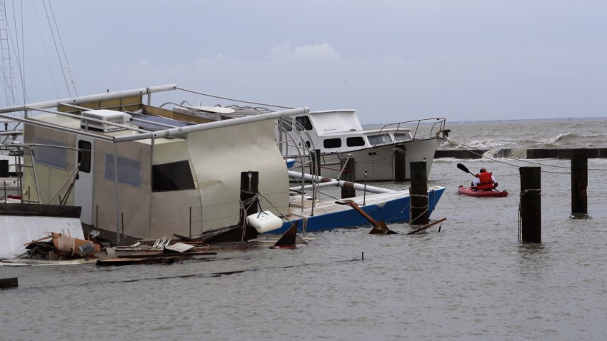 John Nolan uses his kayak to survey the damage to a private marina after it was hit by Hurricane Hanna, Sunday, July 26, 2020, in Corpus Christi, Texas.