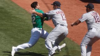 Oakland Athletics' Ramon Laureano (22) tries to run past Houston Astros' Dustin Garneau (13) while charging towards Houston hitting coach Alex Cintron, not shown, in the seventh inning at the Coliseum in Oakland.