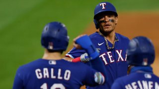 Derek Dietrich #32 of the Texas Rangers is congratulated at home plate by Joey Gallo #13 and Scott Heineman #16 of the Texas Rangers after hitting a three-run home run during the eighth inning against the Colorado Rockies at Coors Field on August 15, 2020 in Denver, Colorado. The Rangers defeated the Rockies 6-4.