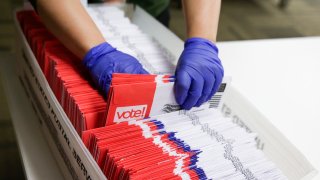 Election workers sort vote-by-mail ballots for the presidential primary at King County Elections in Renton, Washington on March 10, 2020.