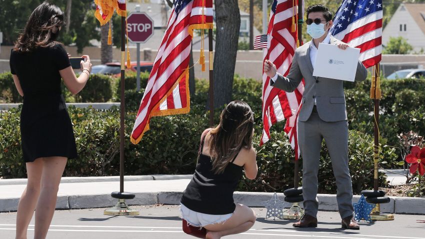 Duc Tran, originally from Vietnam, poses for photos after being sworn in as a new U.S. citizen from his vehicle at a drive-in naturalization ceremony amid the COVID-19 pandemic on July 29, 2020 in Santa Ana, California.