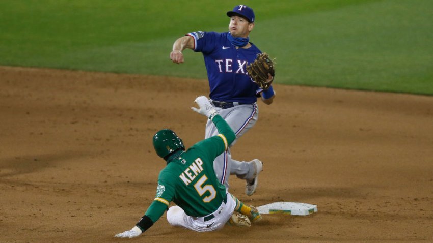 Nick Solak #15 of the Texas Rangers gets out Tony Kemp #5 of the Oakland Athletics at second base and turns a double play in the bottom of the eighth inning at Oakland-Alameda County Coliseum on August 04, 2020 in Oakland, California.