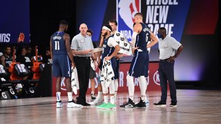 The Dallas Mavericks huddle up during a game against the Phoenix Suns on August 2, 2020 at Visa Athletic Center at ESPN Wide World Of Sports Complex in Orlando, Florida.