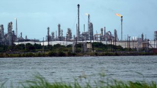 A refinery is seen along the water, Wednesday, Aug. 26, 2020, in Port Arthur, Texas. The energy industry is bracing for catastrophic storm surges and winds as Hurricane Laura cuts a dangerous path toward the coastlines of Texas and Louisiana.