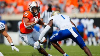 Running back Chuba Hubbard #30 of the Oklahoma State Cowboys tries to make a cut against safety Kendarin Ray #1 of the Tulsa Golden Hurricanes in the third quarter on Sept. 19, 2020 at Boone Pickens Stadium in Stillwater, Oklahoma.