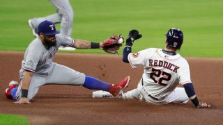 Josh Reddick #22 of the Houston Astros steals second base in the fourth inning against a late tag from Rougned Odor #12 of the Texas Rangers at Minute Maid Park on September 15, 2020 in Houston, Texas.