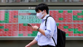 A man walks by an electronic stock board of a securities firm in Tokyo, Monday, Sept. 7, 2020. Asian stock markets were mixed Monday after Wall Street turned in its biggest weekly decline in more than two months.
