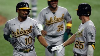 Marcus Semien #10 of the Oakland Athletics celebrates a three-run homerun with Stephen Piscotty #25 against the Texas Rangers in the fifth inning at Globe Life Field on Sept. 12, 2020 in Arlington, Texas.