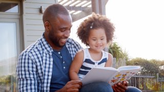 A parent and child reading a book together.