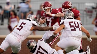 Oklahoma quarterback Spencer Rattler #7 carries against Missouri State defenders Ferrin Manulelua #5), Michael Pope #97 and Von Young #54 in the first half of an NCAA college football game on Sept. 12, 2020, in Norman, Oklahoma.