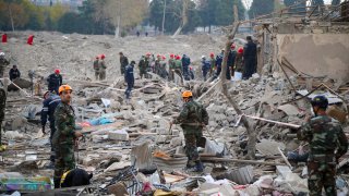 Soldiers and firefighters search for survivors in a residential area that was hit by rocket fire overnight by Armenian forces, early Saturday, Oct. 17, 2020, in Gyanga