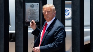 President Donald Trump looks on before signing a plaque as he participates in a ceremony commemorating the 200th mile of the border wall at the international border with Mexico in San Luis, Arizona, June 23, 2020.