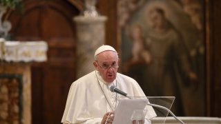 Pope Francis speaks at a lectern.