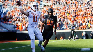 Quarterback Sam Ehlinger #11 of the Texas Longhorns throws the ball away after getting flushed out of the pocket by defensive tackle Israel Antwine #95 of the Oklahoma State Cowboys in the second quarter at Boone Pickens Stadium on Oct. 31, 2020 in Stillwater, Oklahoma.