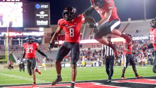 Cornerback Zech McPhearson #8 of the Texas Tech Red Raiders celebrates with linebacker Jacob Morgenstern #41 after running an interception for a touchdown during the second half of the college football game against the West Virginia Mountaineers on October 24, 2020 at Jones AT&T Stadium in Lubbock, Texas.