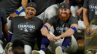 Los Angeles Dodgers manager Dave Roberts and third baseman Justin Turner pose for a group picture after the Dodgers defeated the Tampa Bay Rays 3-1 in Game 6 to win the baseball World Series, Tuesday, Oct. 27, 2020, in Arlington, Texas.