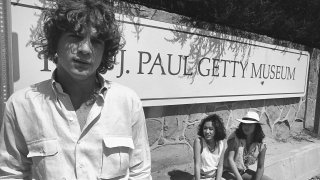 John Paul Getty III, grandson of billionaire Paul Getty, stands with two friends in front of entrance to the Getty Villa Museum in Santa Monica, circa 1979.