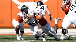 DeMarvion Overshown #0 of the Texas Longhorns sacks Jarret Doege #2 of the West Virginia Mountaineers in the third quarter at Darrell K Royal-Texas Memorial Stadium on Nov. 7, 2020 in Austin, Texas.