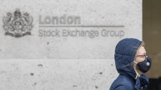 A pedestrian wears a protective face mask as she walks past the London Stock Exchange in London, U.K., on Monday, Mar. 2, 2020.