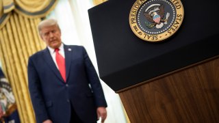 US President Donald Trump listens during a Medal of Freedom ceremony for retired football Lou Holtz in the Oval Office of the White House December 3, 2020, in Washington, DC.
