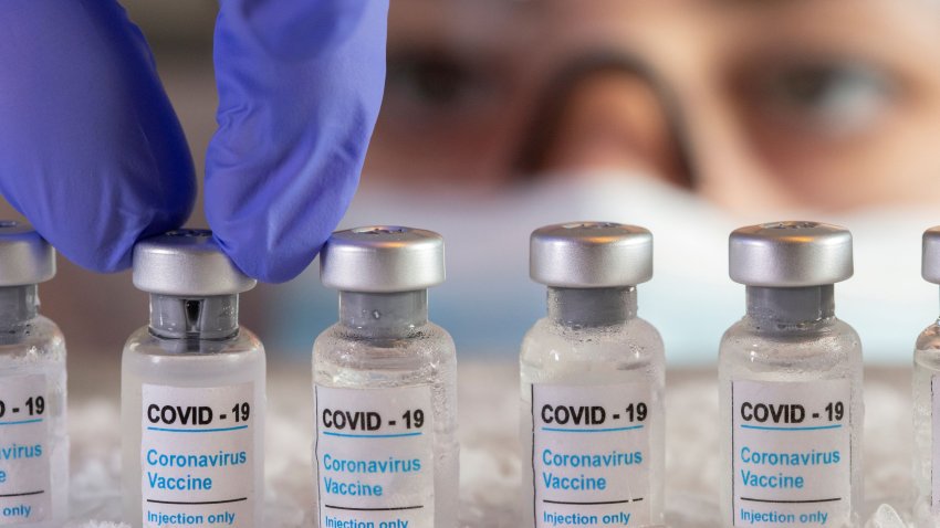 Woman holds vials labelled “COVID-19 Coronavirus Vaccine” over dry ice in this illustration taken, December 5, 2020.