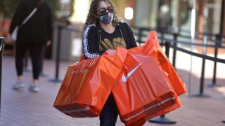 A woman carries Nike shopping bags at the Citadel Outlet mall, as the global outbreak of the coronavirus disease (COVID-19) continues, in Commerce, California, U.S., December 3, 2020.