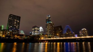 Buildings stand in the downtown skyline at night past the Colorado River in Austin, Texas, U.S., on Saturday, April 4, 2015.