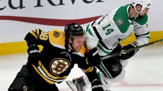 BOSTON - FEBRUARY 27: Boston Bruins right winger David Pastrnak and Dallas Stars left winger Jamie Benn fight for a loose puck in the first period. The Boston Bruins host the Dallas Stars during a regular season NFL hockey game at TD Garden in Boston on Feb. 27, 2020.