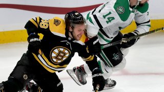 BOSTON - FEBRUARY 27: Boston Bruins right winger David Pastrnak and Dallas Stars left winger Jamie Benn fight for a loose puck in the first period. The Boston Bruins host the Dallas Stars during a regular season NFL hockey game at TD Garden in Boston on Feb. 27, 2020.