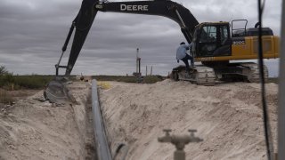 Workers lay a pipeline in Lea County, New Mexico, U.S., on Thursday, Sept. 10, 2020. With the U.S. oil industry reeling from the collapse in demand this year, the New Mexico shale patch has emerged as the go-to spot for drillers desperate to squeeze as much crude from the ground without bleeding cash.