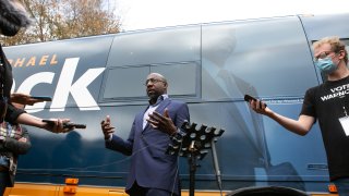 Democratic U.S. Senate candidate Raphael Warnock talks with the press outside his campaign bus during a drive-up worship service at St. James Missionary Baptist Church on December 13, 2020 in Columbus, Georgia. Warnock is facing incumbent Sen. Kelly Loeffler (R-GA) in a runoff election that will take place on January 5th. The results of two Georgia U.S. Senate races will determine which party controls the Senate.
