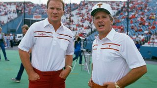 Heads coaches Barry Switzer of the University of Oklahoma (L) and Fred Akers of the University of Texas (R) looks on prior to there NCAA football game October 11, 1986 at the Cotton Bowl in Dallas, Texas.