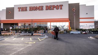 An employee gathers shopping carts from the parking lot of a Home Depot Inc. store in Chicago, Illinois, U.S., on Monday, Nov. 23, 2020.