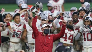 Oklahoma Sooners head coach Lincoln Riley raises the trophy after winning the Big 12 Championship game between Oklahoma and Iowa State on Dec. 19, 2020 at AT&T Stadium in Arlington, Texas.
