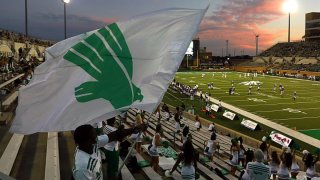 Supporters of the North Texas Mean Green wave a team flag as they take on the Houston Baptist Huskies during a game at Apogee Stadium on Sept. 5, 2020 in Denton, Texas.