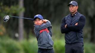 Tiger Woods, right, watches as his son Charlie tees off on the 12th hole during a practice round of the Father Son Challenge golf tournament, Thursday, Dec. 17, 2020, in Orlando, Florida.